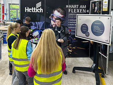 Leon Timmert, Industriemechaniker im ersten Lehrjahr, hilft Schüler*innen bei ihren Einstiegsmöglichkeiten in die Hettich-Welt. Foto: Hettich