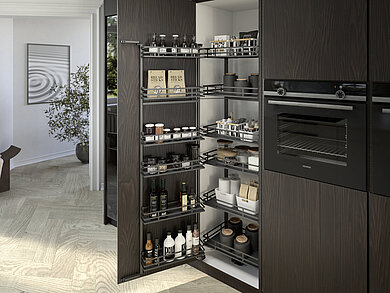 Optymalna organizacja i wygodny dostęp nawet do najdalszych zakamarków wysokiej szafy. System uchylno-wysuwany „Iseo” od Hettich to ergonomiczne rozwiązanie, które ułatwia codzienne użytkowanie. Elegancki płaski reling w kolorze antracytowym (linia wzornicza 400) podkreśla minimalistyczną formę tego produktu. Zdjęcie Hettich.